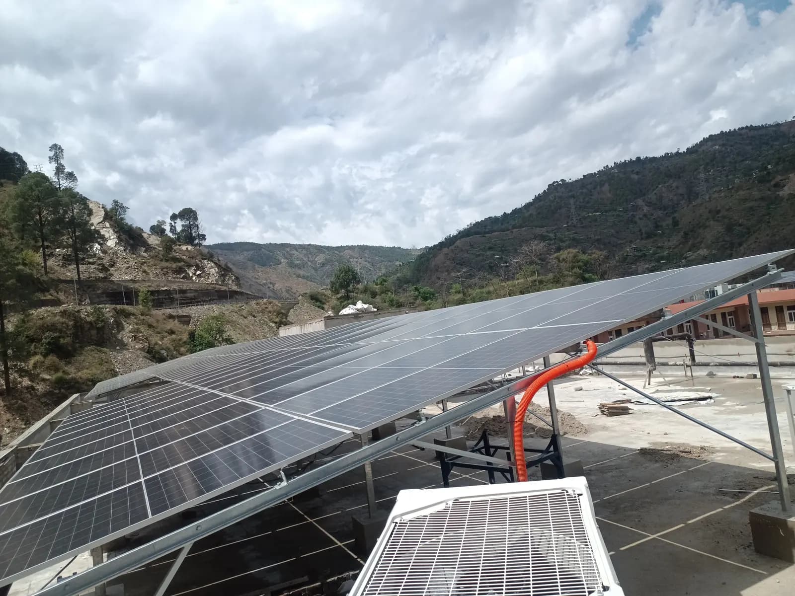 Raised solar panel array on an IIT Mandi rooftop with the surrounding hills