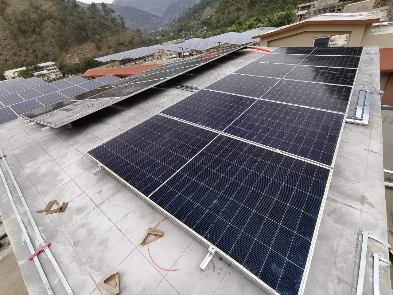 Rows of solar modules and their mounting rails on an IIT Mandi rooftop